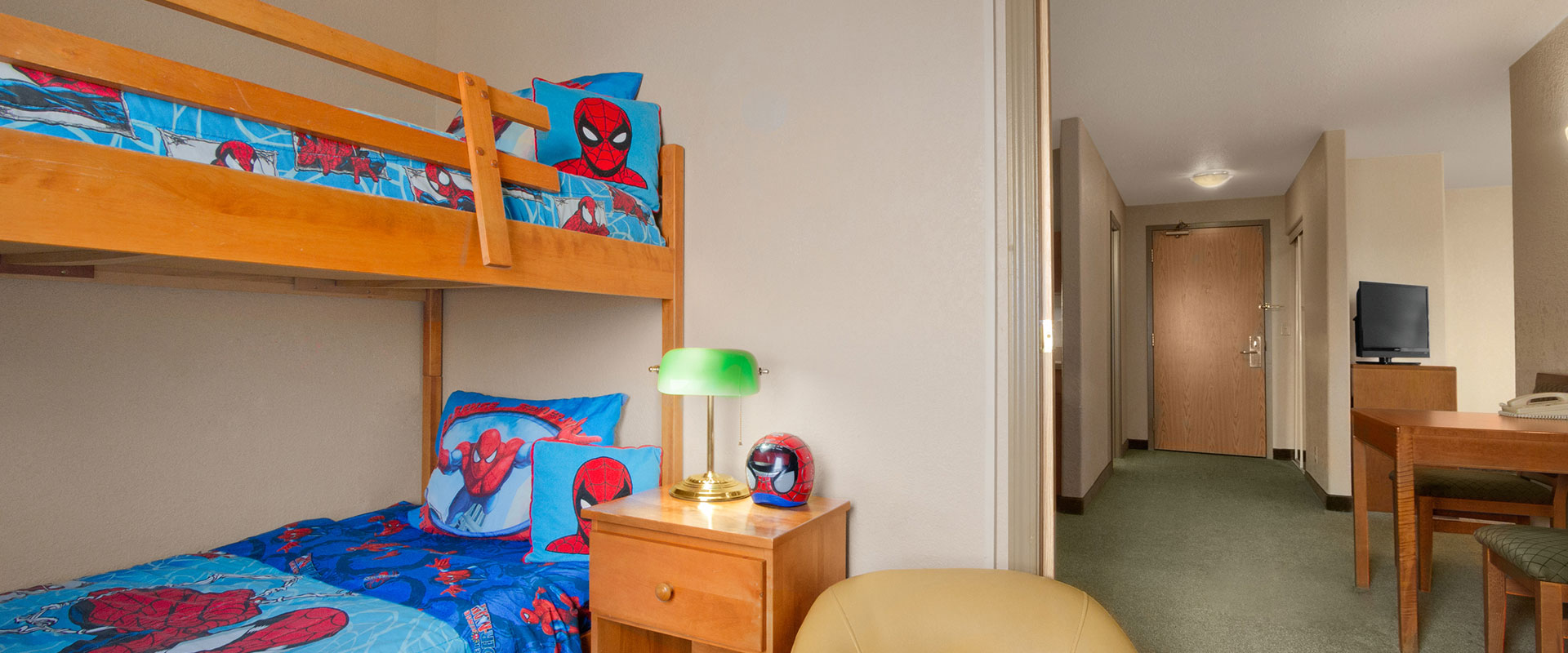 Large sized view of a kid friendly suite featuring bunk beds with Spiderman bed linen and pillows at Days Inn Red Deer, Alberta.

